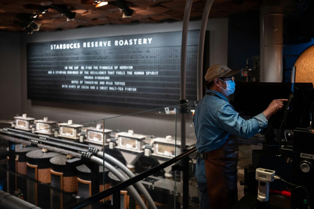 A barista operates machinery at Starbucks Reserve Roastery, showcasing the coffee production process.